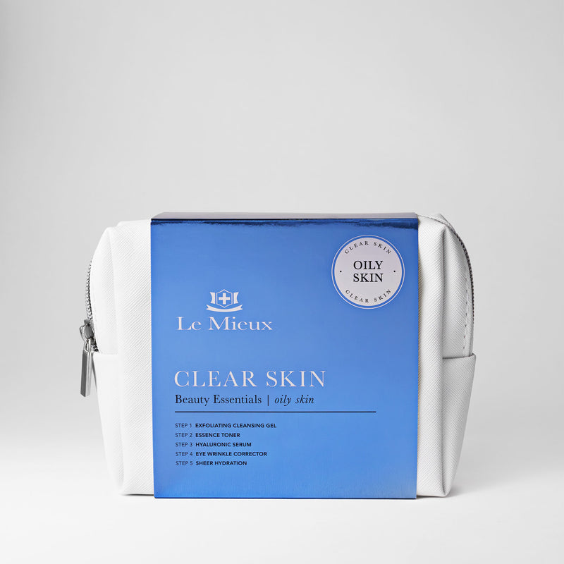 White bag with silver zipper and blue sleeve that says Clear Skin Beauty Essentials with Le Mieux logo in front of a light gray background.