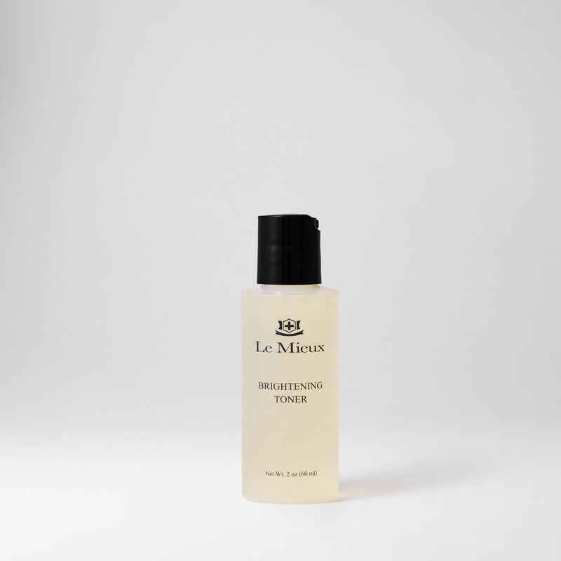 2 oz bottle of light yellow Brightening Toner with black lid isolated on light gray background