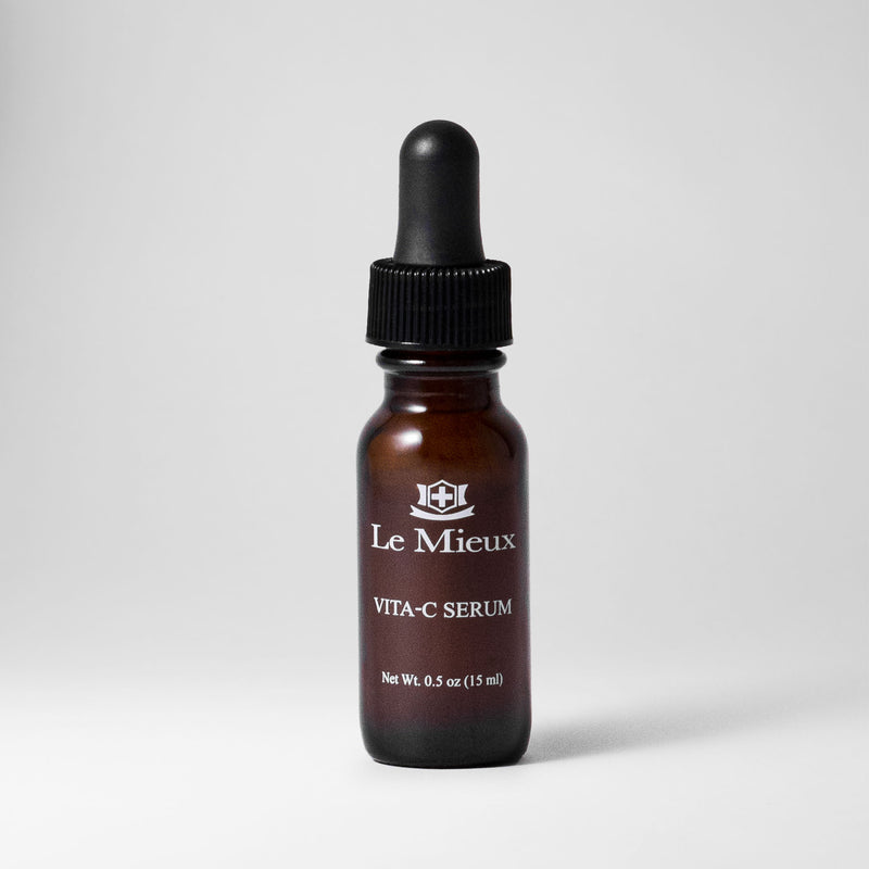 Vita-C Serum 0.5 oz amber bottle with black dropper lid isolated on a light grey background 